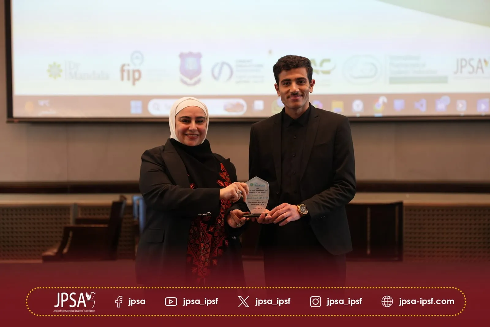 An award presented in front of a projection screen