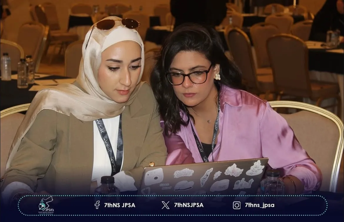 Two people working together on a laptop in the conference hall