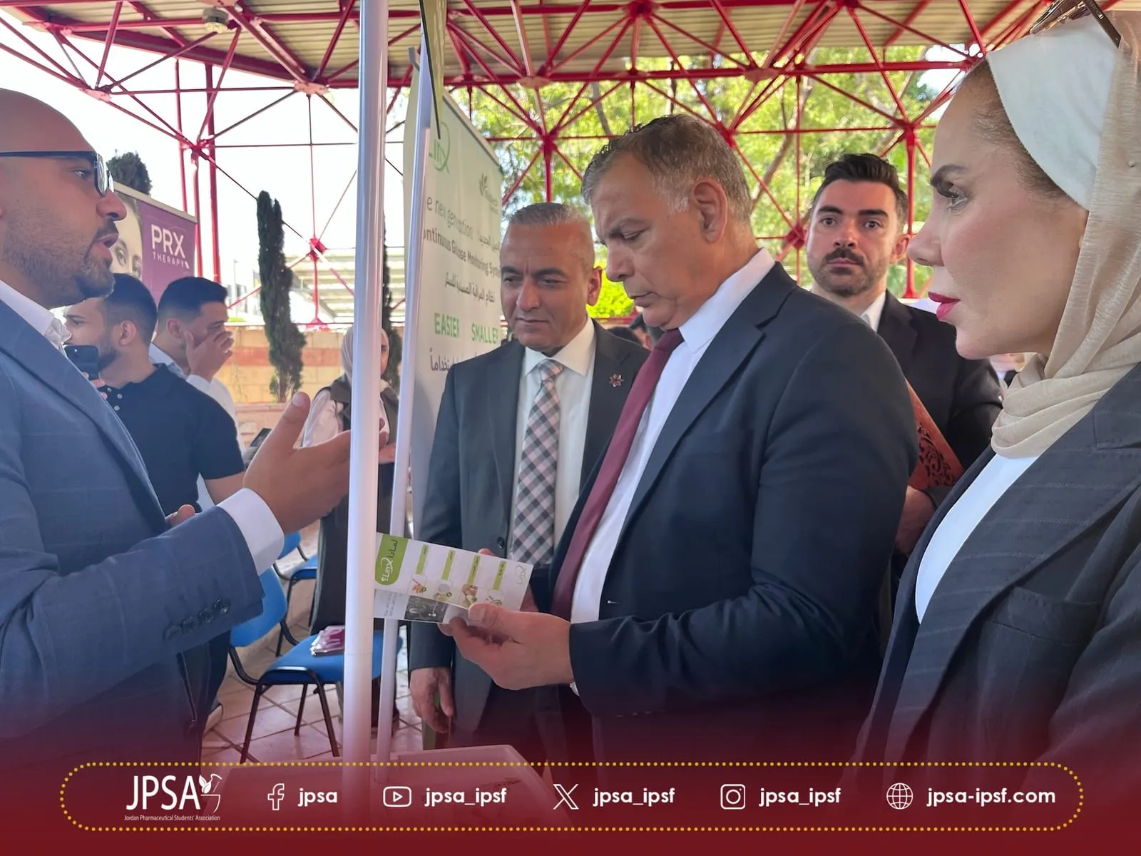 Visitors looking at a leaflet at an outdoor exhibition stand