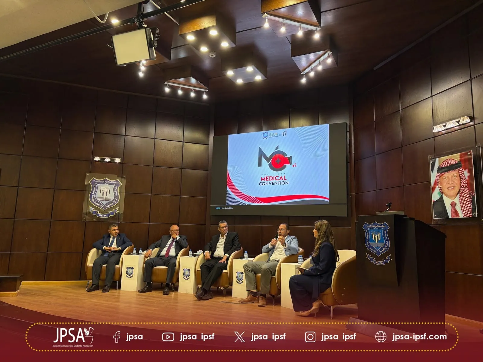 A panel of five seated on stage, under the Medical Convention screen